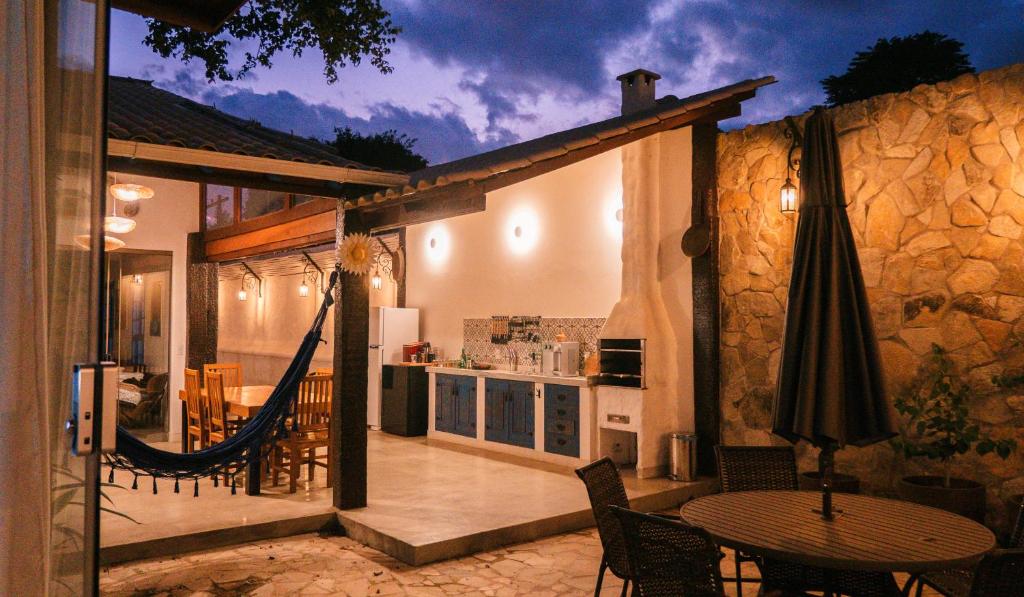 an outdoor patio with a hammock and a kitchen at Villa Mykonos - Experiência Grega Exclusiva em Tiradentes - 5 Suítes de Luxo in Tiradentes