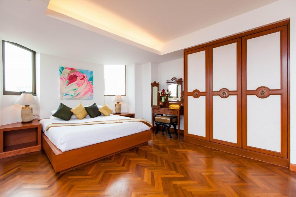 a bedroom with a large bed and a desk at The Grand Sathorn in Bangkok
