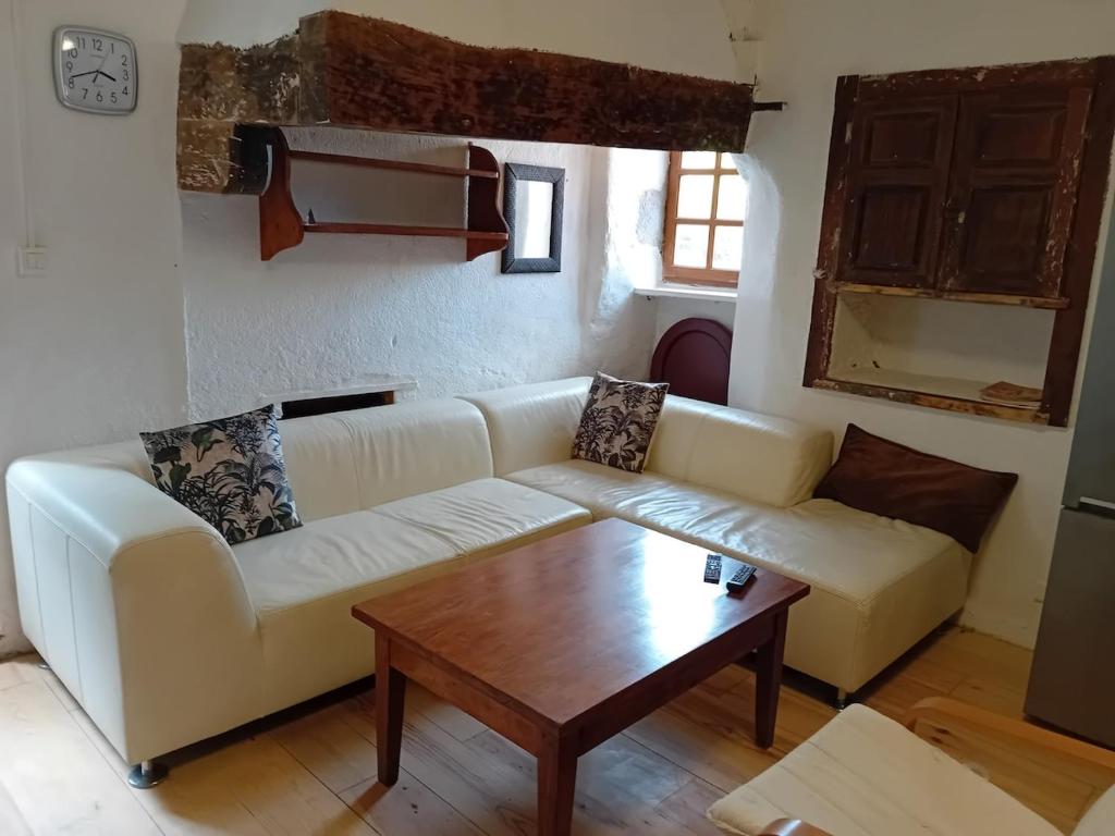 un salon avec un canapé et une table basse dans l'établissement Maison Typique Lotoise Saint Cirq Lapopie, à Saint-Cirq-Lapopie