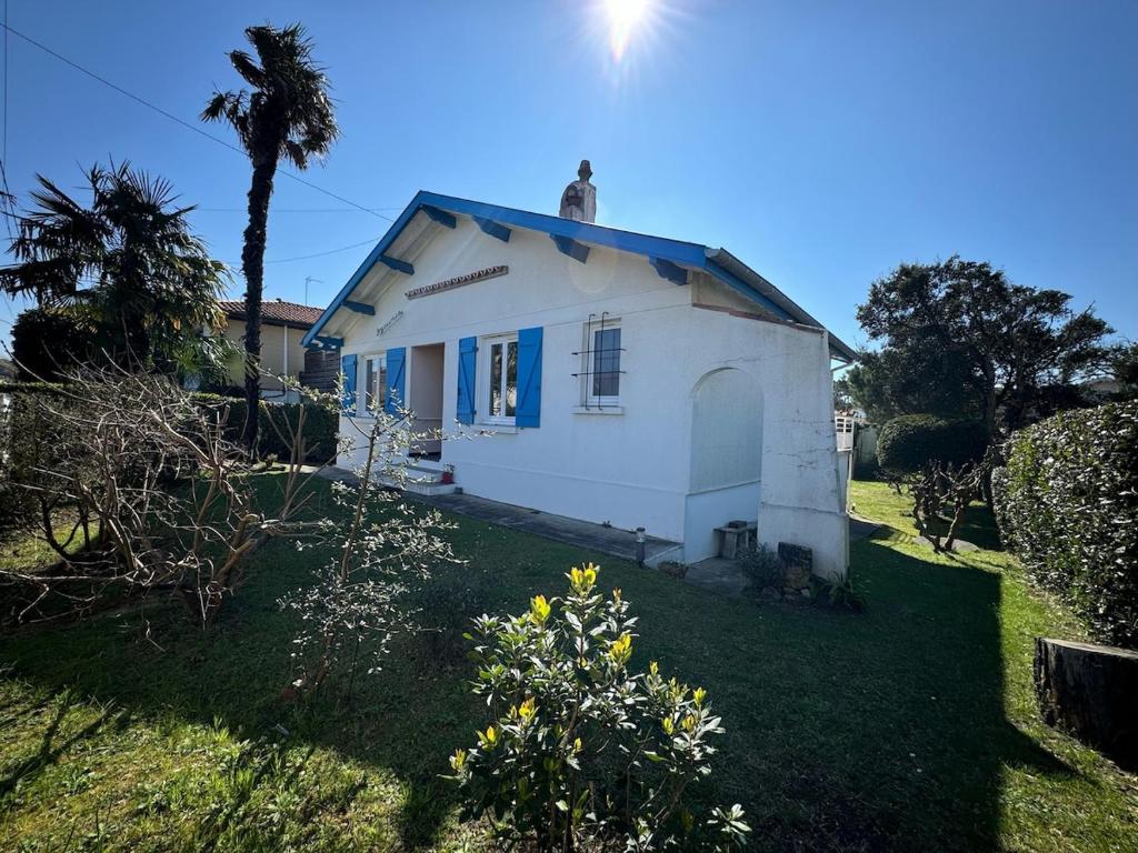 une petite maison blanche avec un toit bleu dans l'établissement Villa Dziunia Townhouse with garden, à Tarnos