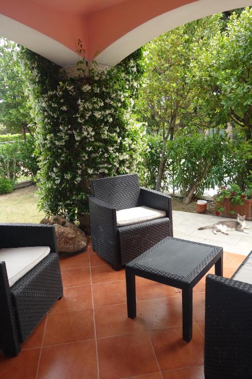 a patio with wicker chairs and a table and a chair and a tableearcher at Vacanze a Villa Ortensia in San Teodoro
