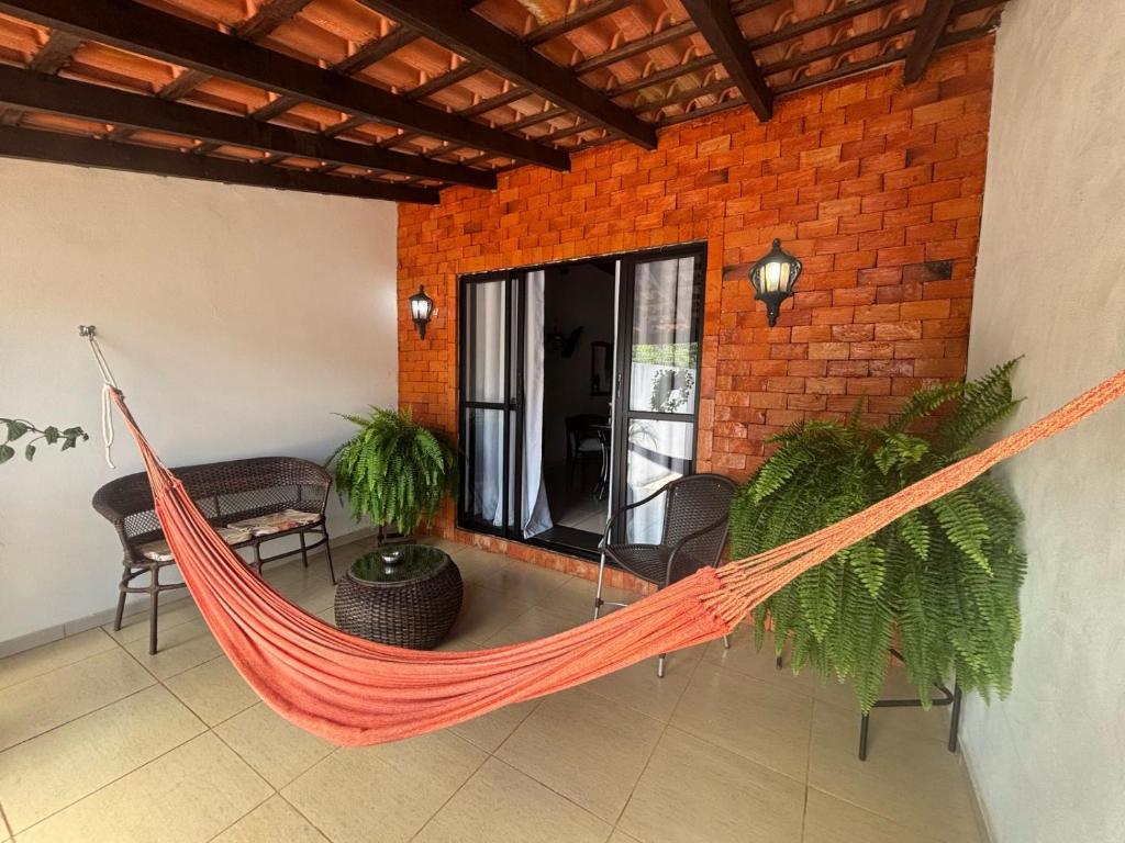 a hammock in a room with a brick wall at Privacidade, WiFi, Microondas, Prime Vídeo, Alexa in Chapada dos Guimarães