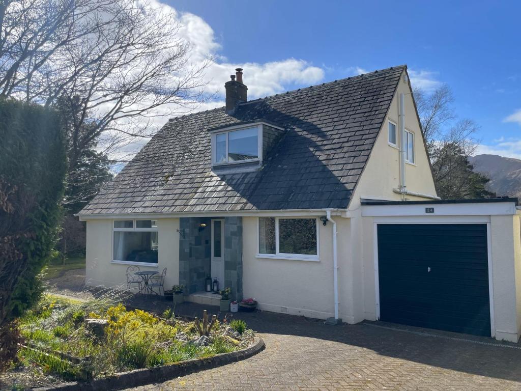 a white house with a large garage at Fern Cottage in Portinscale