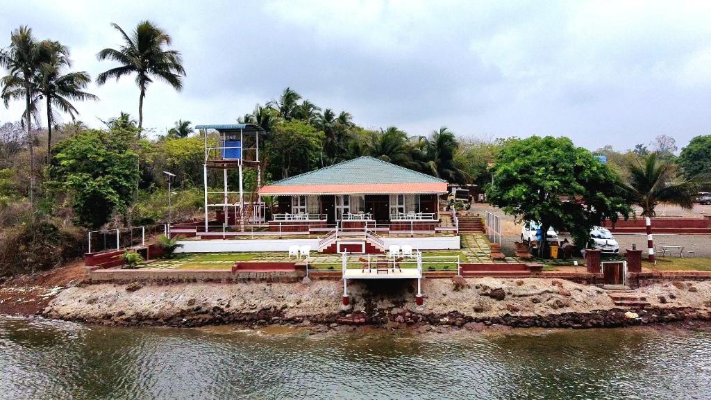 a house on the side of a river at Mai's Beach Resort in Malvan