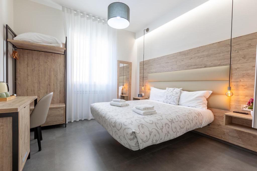 a bedroom with a white bed and a desk and a desk at Oneira Rooms in Agrigento