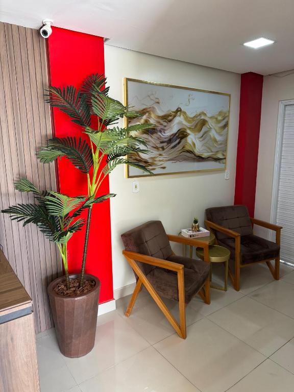 ソブラルにあるSeller Hotelの椅子2脚とヤシの木のある待合室