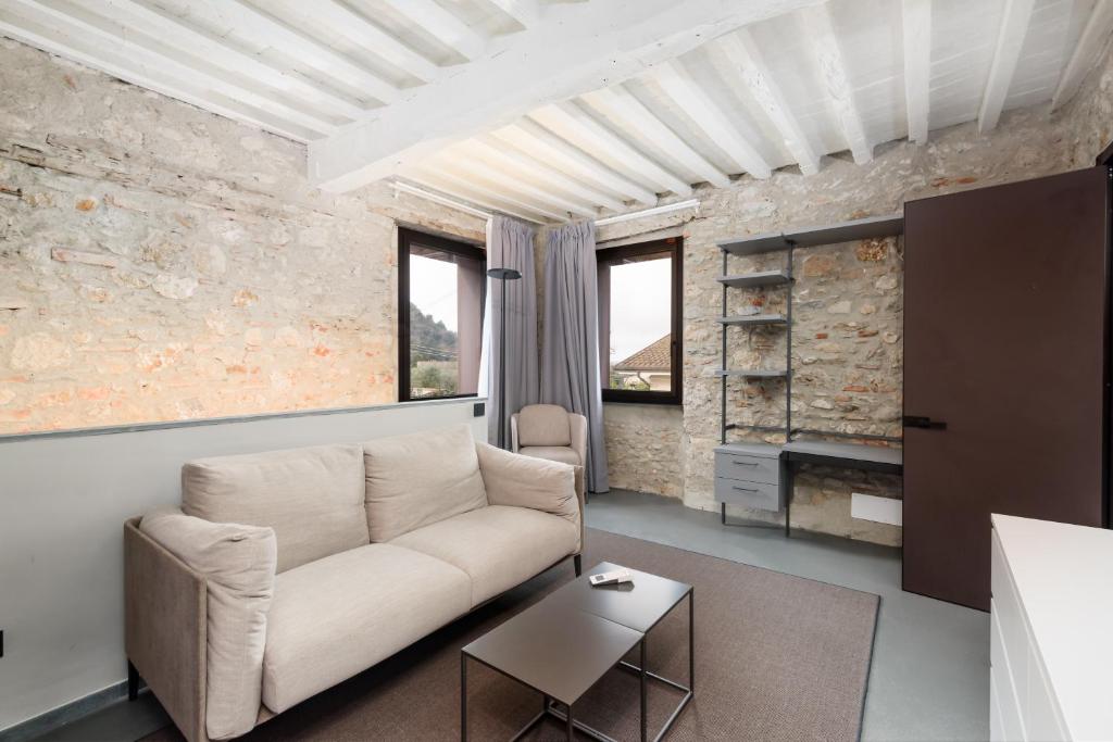 a living room with a couch and a table at VOMAN Luxury Apartments in Pietrasanta