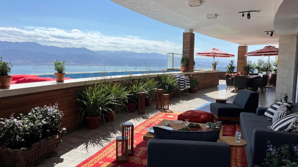 un patio avec chaises et tables et une piscine dans l'établissement Lady Balfour by Villa Balfour Eilat, à Eilat
