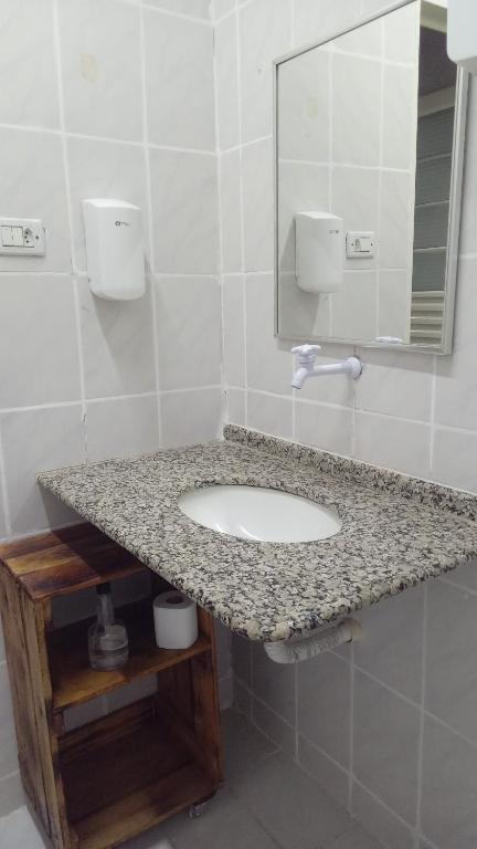 a bathroom with a sink and a mirror at Casarao hostel dormitorio in Cuiabá