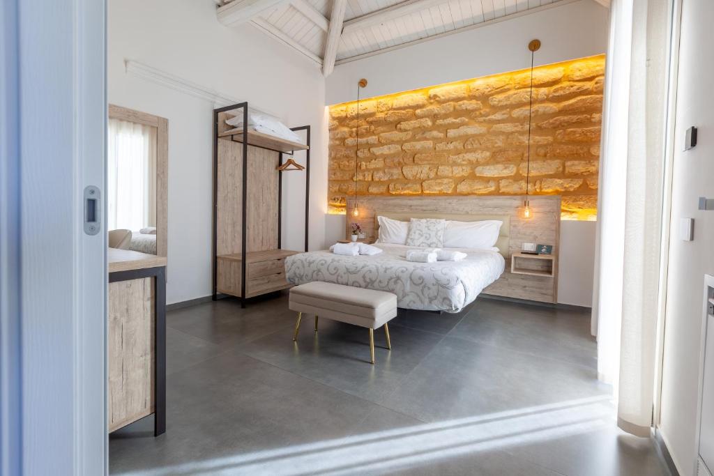 a bedroom with a white bed and a stone wall at Oneira Rooms in Agrigento