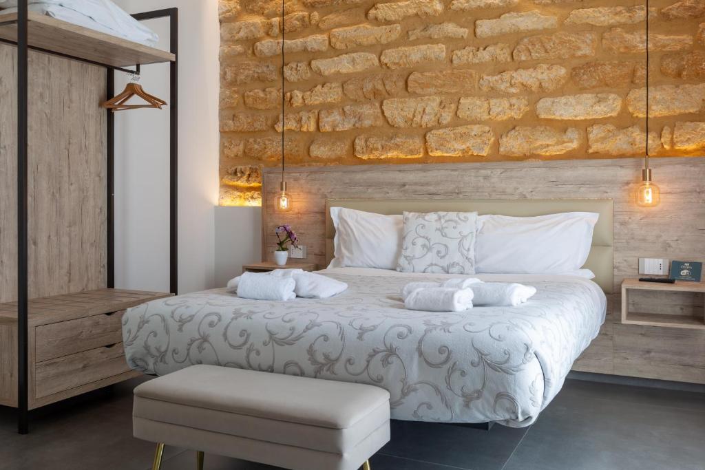 a bedroom with a large bed with towels on it at Oneira Rooms in Agrigento