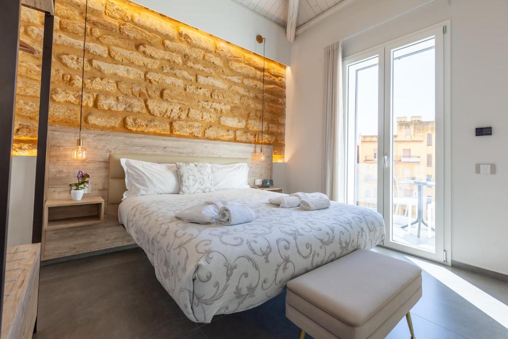a bedroom with a bed with two towels on it at Oneira Rooms in Agrigento