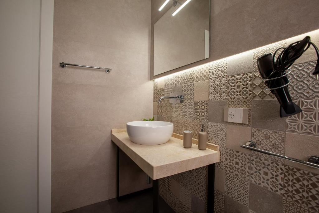 a bathroom with a sink and a mirror at Oneira Rooms in Agrigento