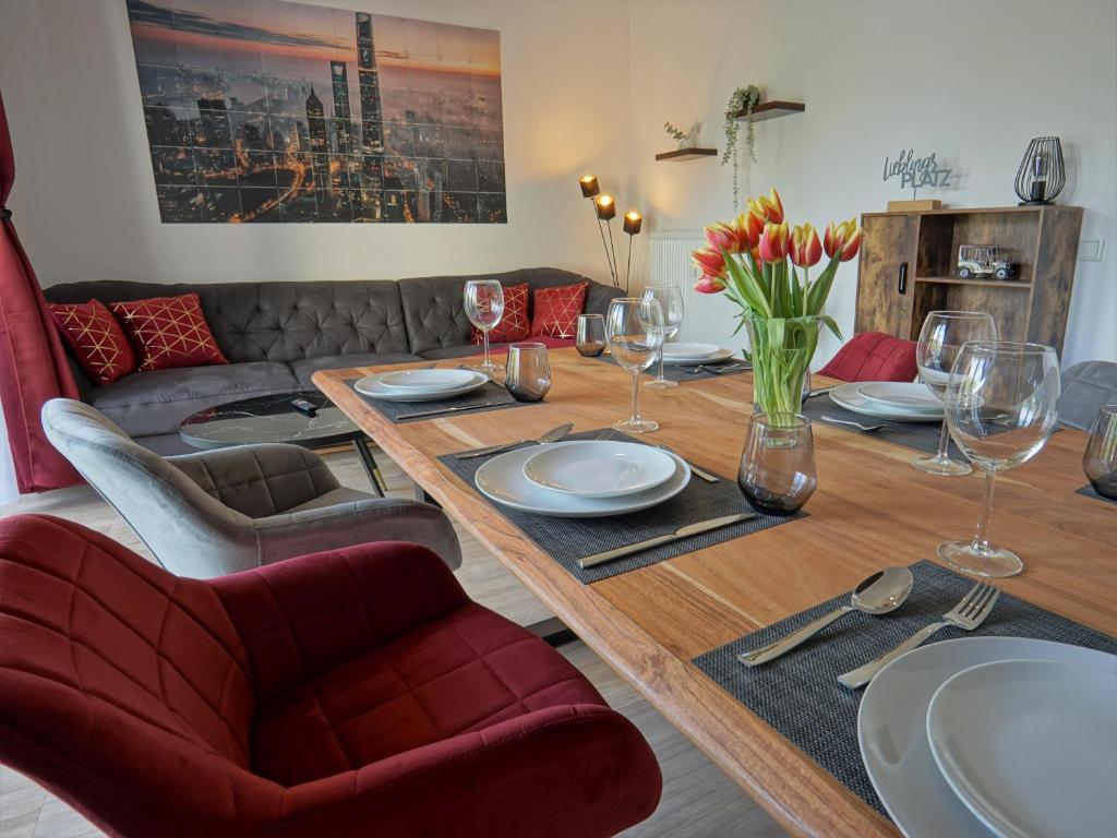 a dining room table with plates and wine glasses at HOGULU - 3 - RAUM - App 25 mit Balkon in Brandenburg an der Havel