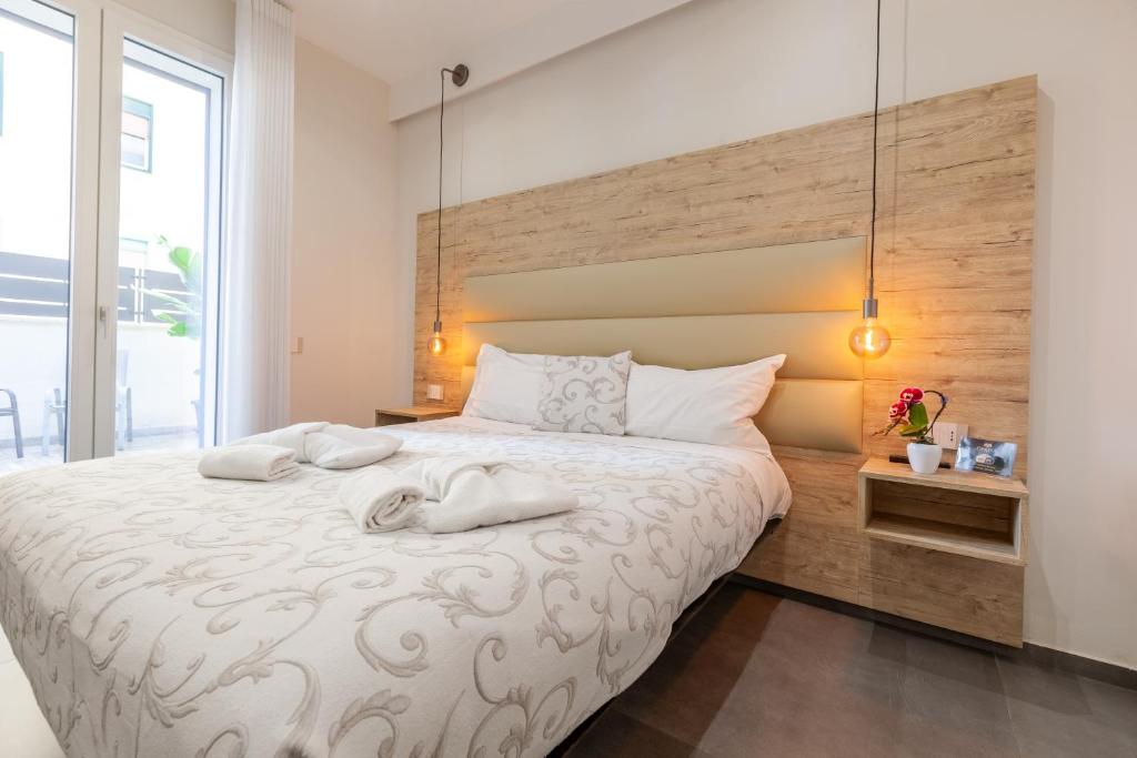 a bedroom with a large bed with two towels on it at Oneira Rooms in Agrigento