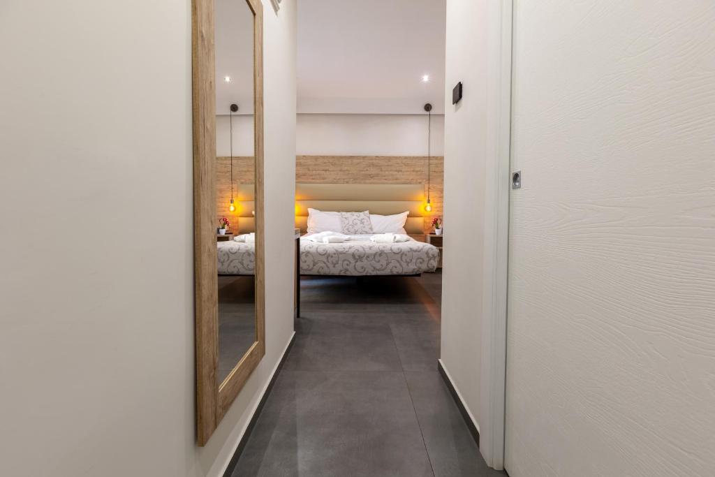 a hallway with a mirror and a bed in a room at Oneira Rooms in Agrigento