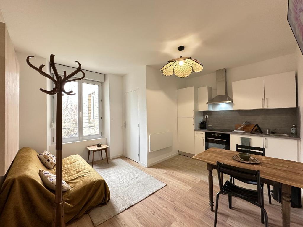 un salon avec une table et une cuisine dans l'établissement Calvi - Paisible et chaleureux, à Reims