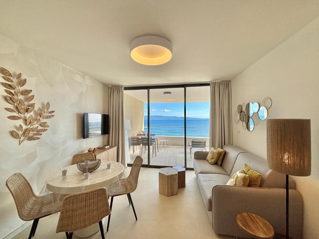 a living room with a couch and a table at Appartement Eden A sanguinaires vue mer avec piscine résidence in Ajaccio