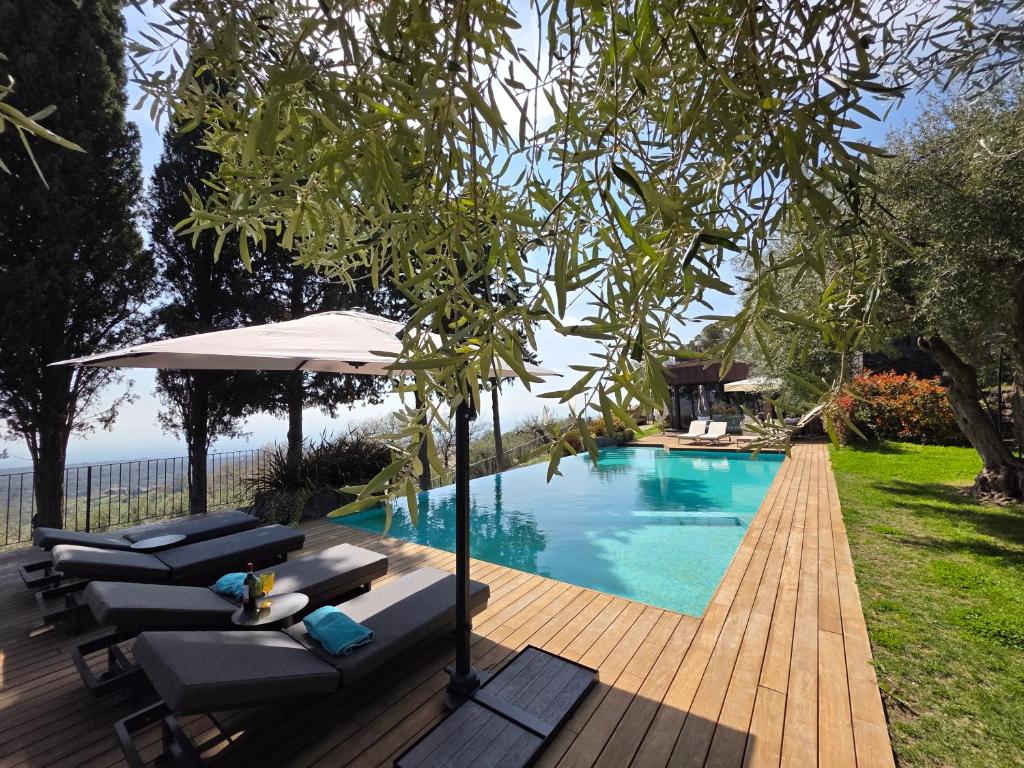 a swimming pool with chairs and an umbrella next to it at Rahal Luxury- Between Etna & Sea in Catania