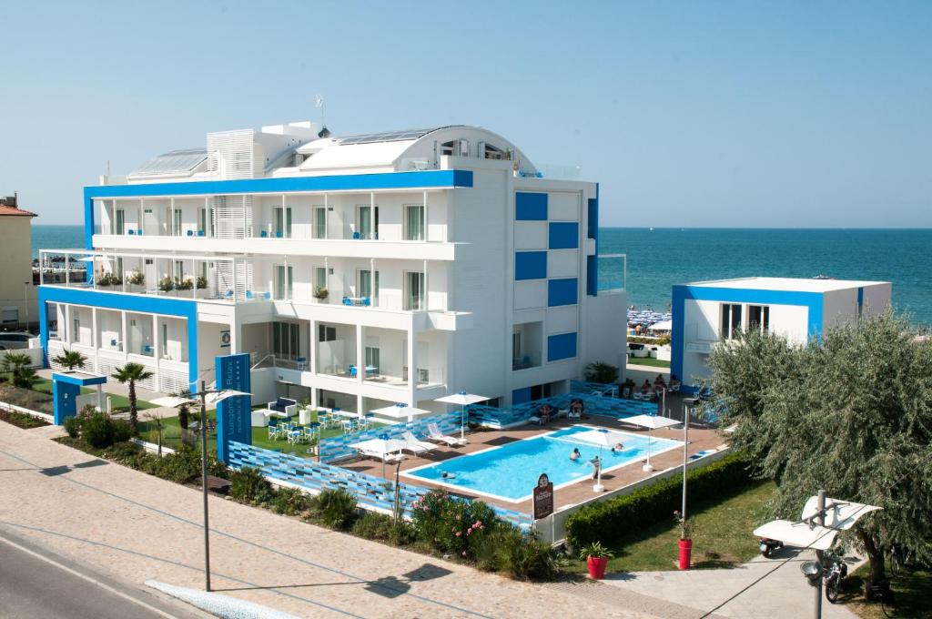 a building with a swimming pool next to the ocean at Lungomare Relax Residence in Misano Adriatico