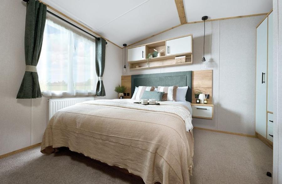 a bedroom with a large bed and a large window at Unity Skirlington Coast Yorkshire in Skipsea