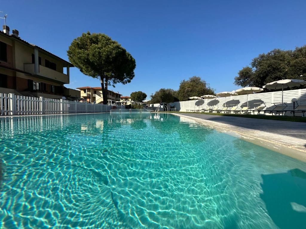 a large swimming pool with blue water at Villaggio Mietta in Castiglioncello