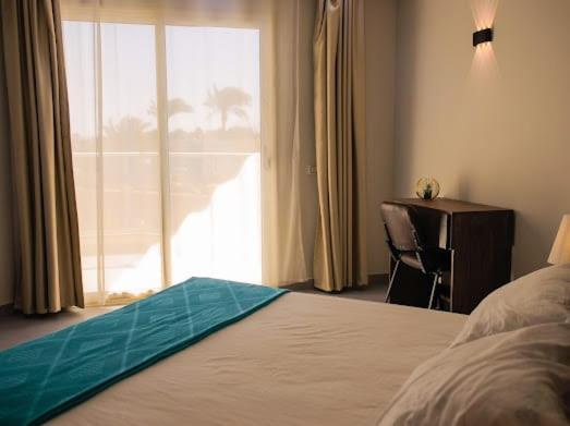 une chambre avec un lit, un bureau et une fenêtre dans l'établissement Scandic Resort Hurghada, à Hurghada