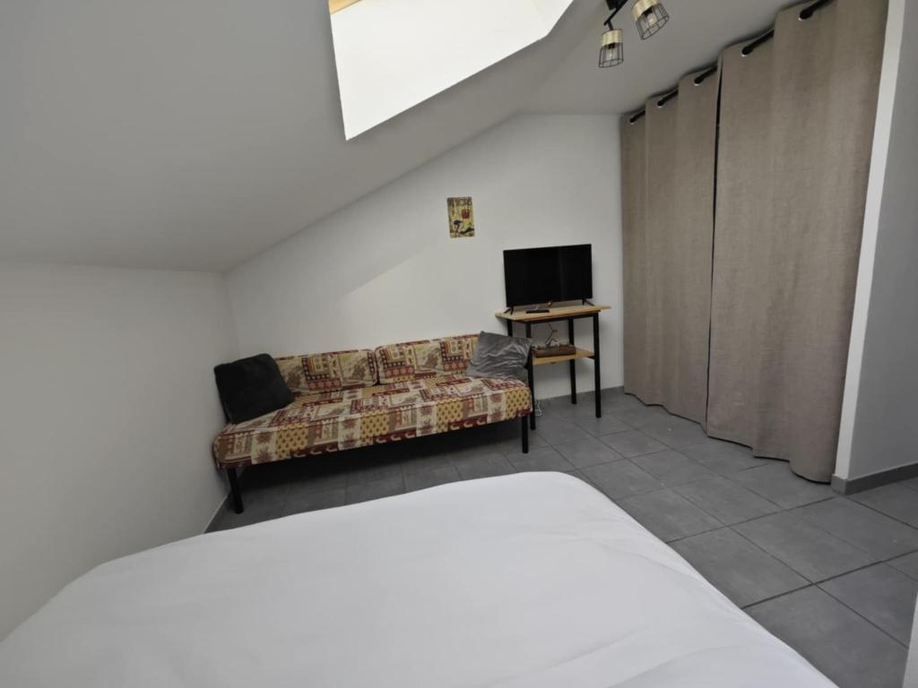 a living room with a couch and a television at Serre Chevalier 2 pièces à 150 m du télécabine Prorel in Briançon