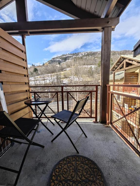 - deux chaises et une table sur une terrasse couverte avec vue dans l'établissement Serre Chevalier 2 pièces à 150 m du télécabine Prorel, à Briançon