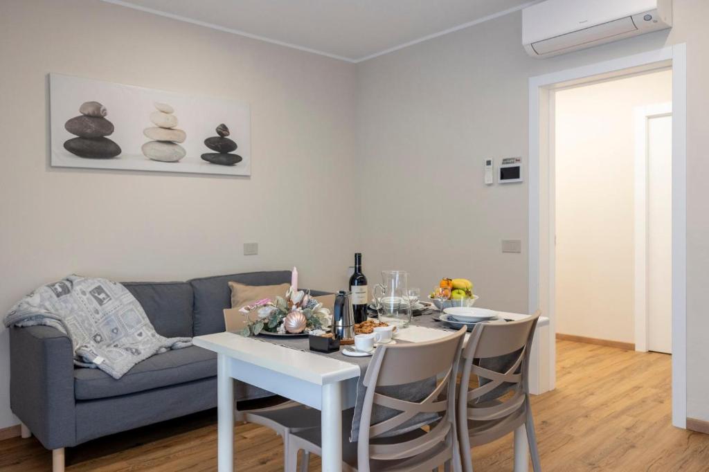 a living room with a table and a blue couch at Casa Belfiore, Darfo Boario Terme Ospitar in Boario Terme