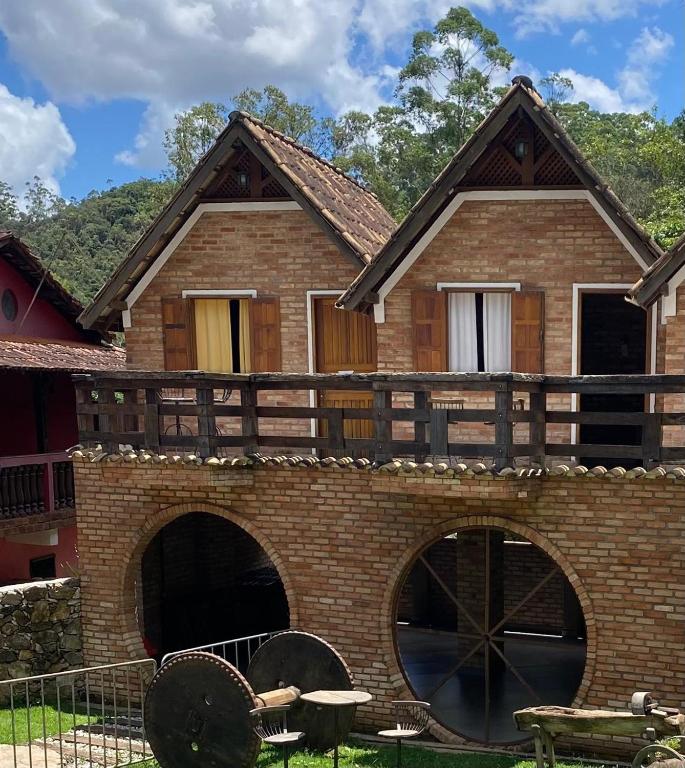 a brick house with a wooden roof and two arches at Chalé Esmeralda in Ouro Preto