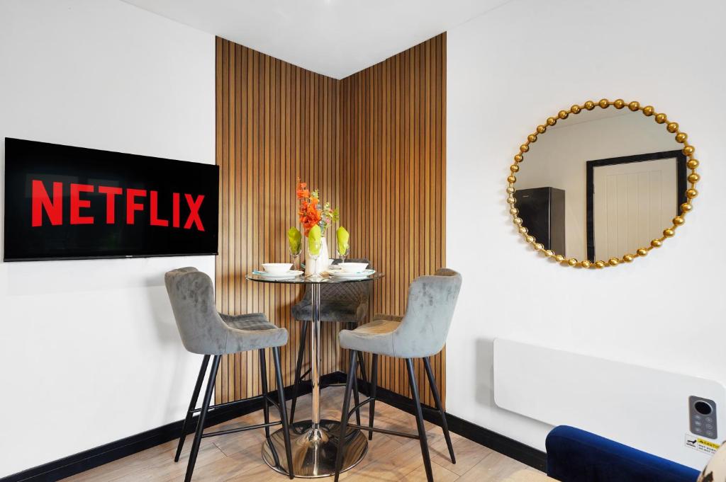a dining room with a table and chairs and a mirror at Boutique Penthouse in Yorkshire - Top Floor in Castleford