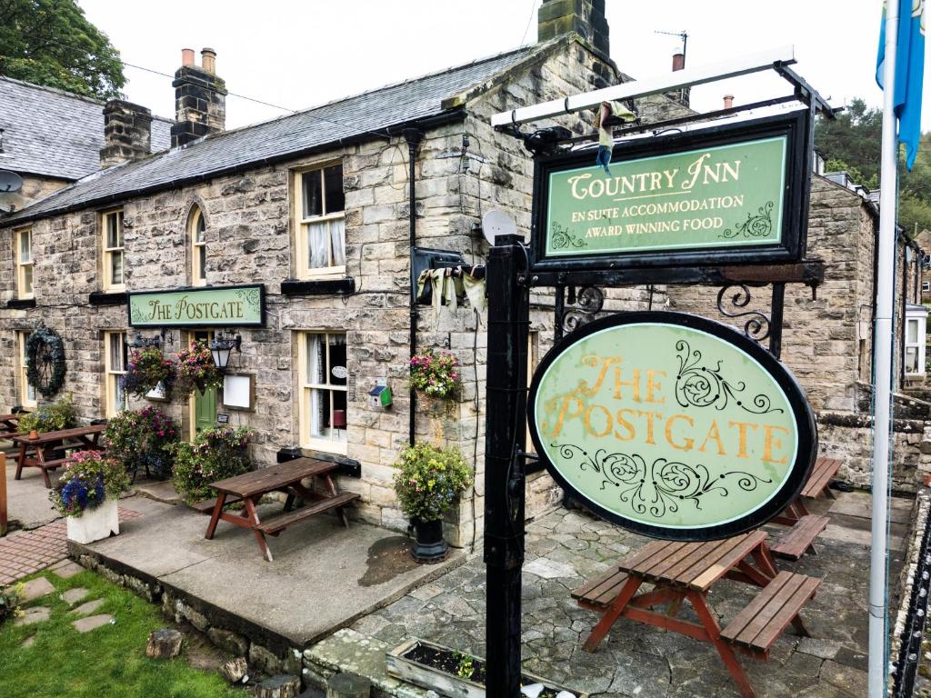 a sign in front of a stone building at The Postgate Inn in Egton