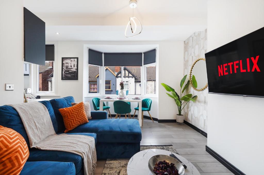 a living room with a blue couch and a table at Stylish Yorkshire Gem - Sleeps 4 - Great Location in Castleford