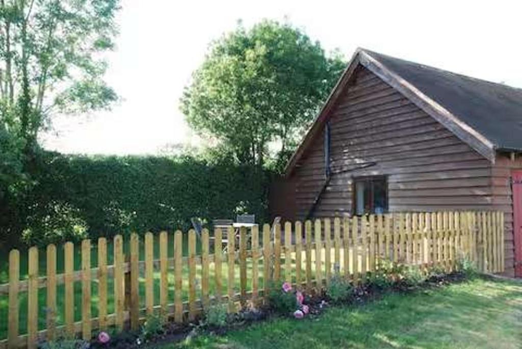 a wooden fence in front of a wooden house at The Chalet is pet friendly on a farm near Malvern in Welland