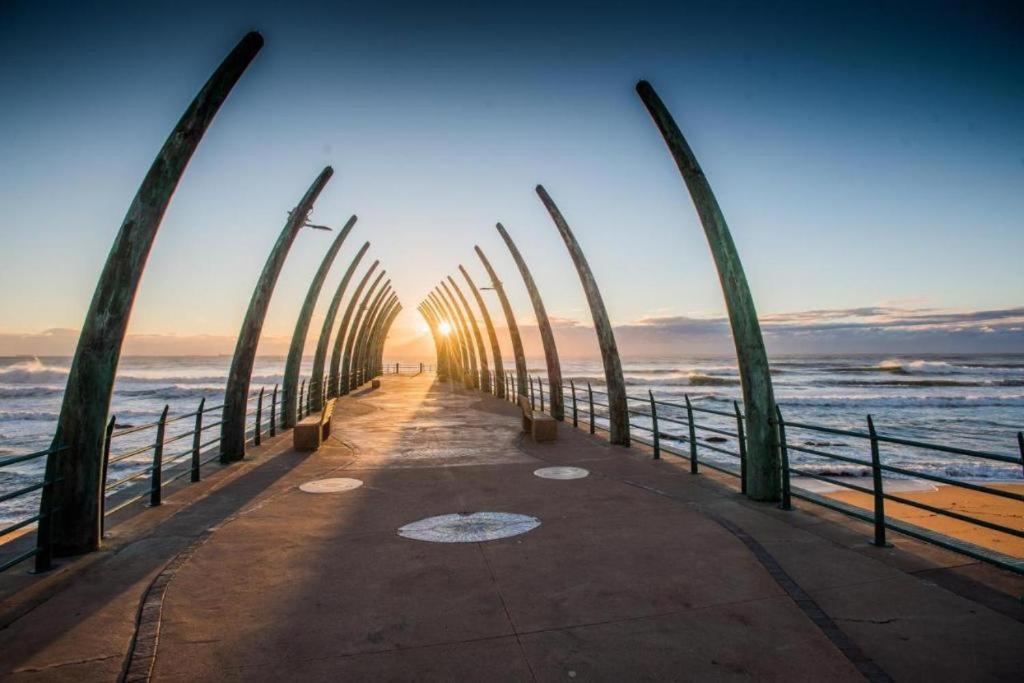 a pier with palm trees on the beach at The Pearls of Umhlanga, or Oceans Apts in Durban