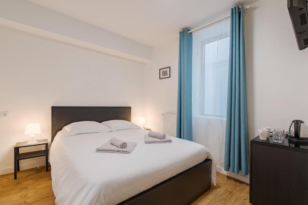 Un dormitorio con una gran cama blanca y una ventana. en TenQuaRoom - Sublime Chambre Proche du Capitole, en Toulouse