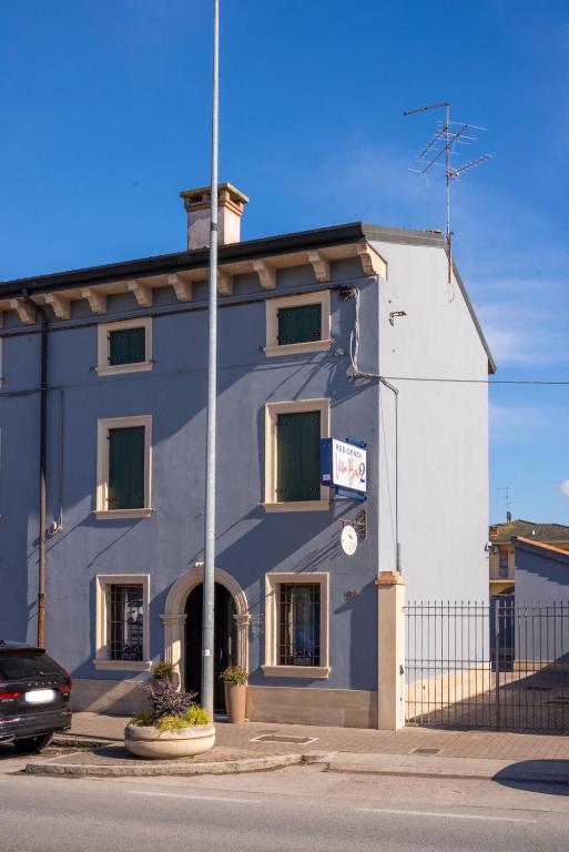 a blue building with a car parked in front of it at Residenza Villa Bella 2 in Mozzecane