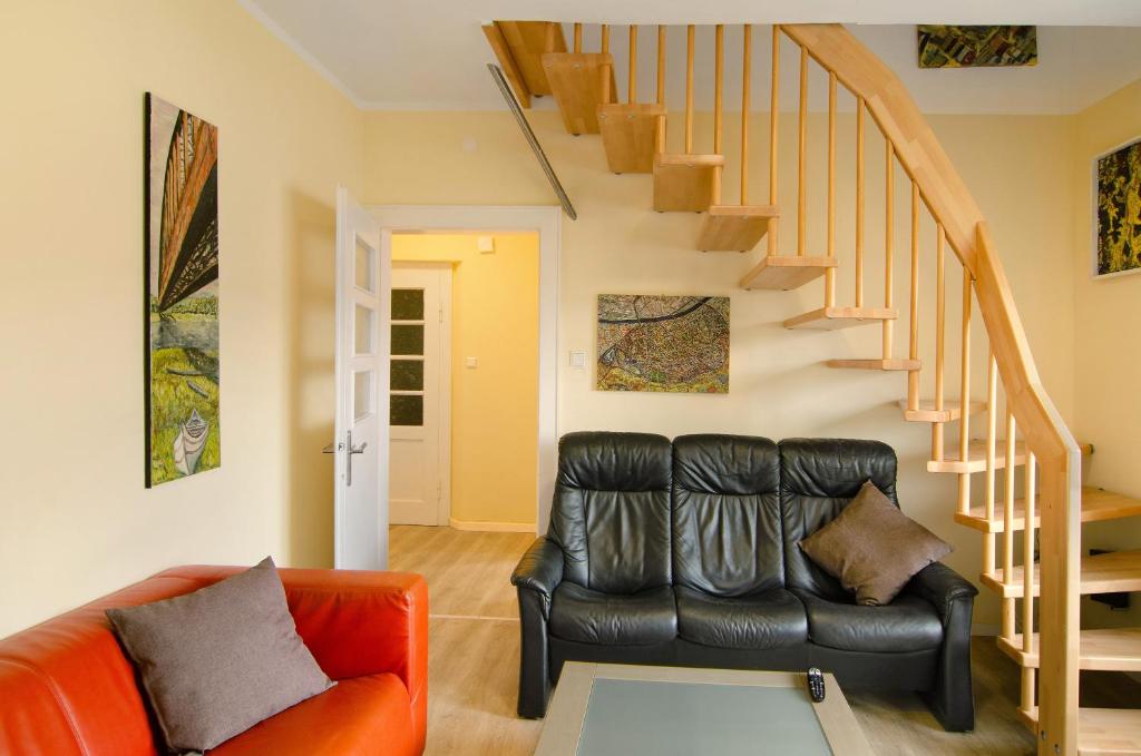 a living room with a leather couch and stairs at Haus unterm Räuschenberg in Höxter
