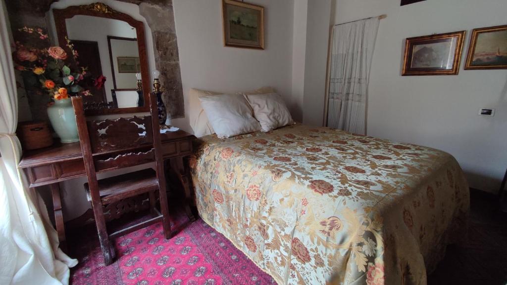 a bedroom with a bed and a mirror and a table at Boccaletto Incantato in Viterbo