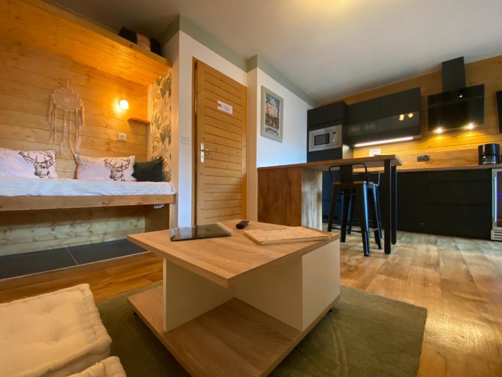 Cette petite chambre comprend un lit et une table. dans l'établissement My 3 stars BEE HAPPY studio, à Brides-les-Bains