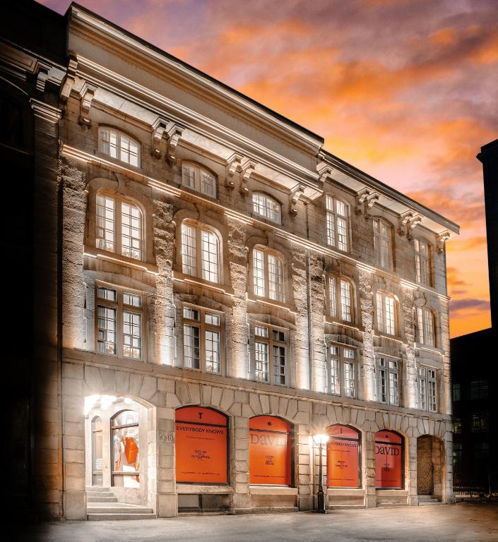 a painting of a large stone building with a sunset at David Hotel in Montréal