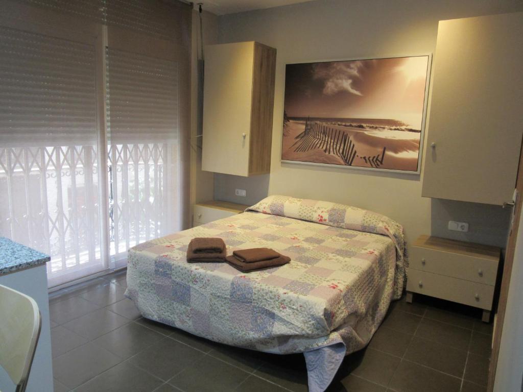 1 dormitorio con 1 cama y una pintura en la pared en Apartamentos Adressadors, en Valencia