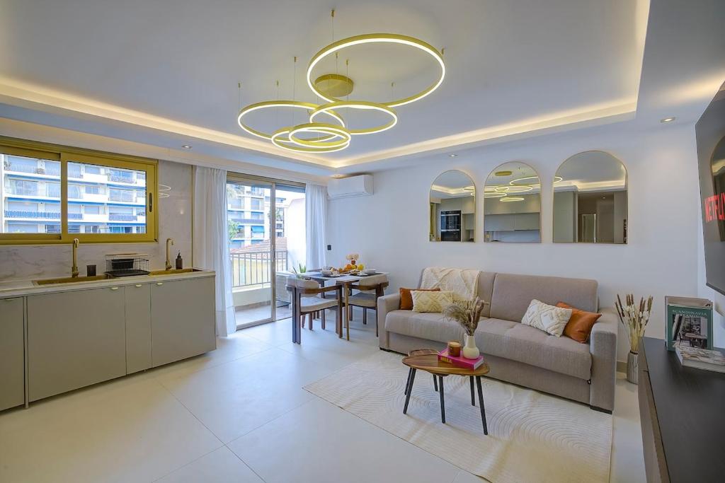 un salon et une cuisine avec un canapé et une table dans l'établissement Luxe Azure Escape I Collection, à Juan-les-Pins