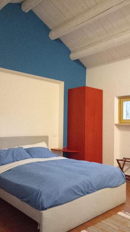 a bedroom with a bed with blue sheets and red cabinets at La Fetuseria bistrot & camere in Senigallia