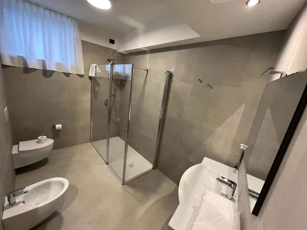 a bathroom with a shower and a toilet and a sink at Hotel Villa Margherita in Limone sul Garda