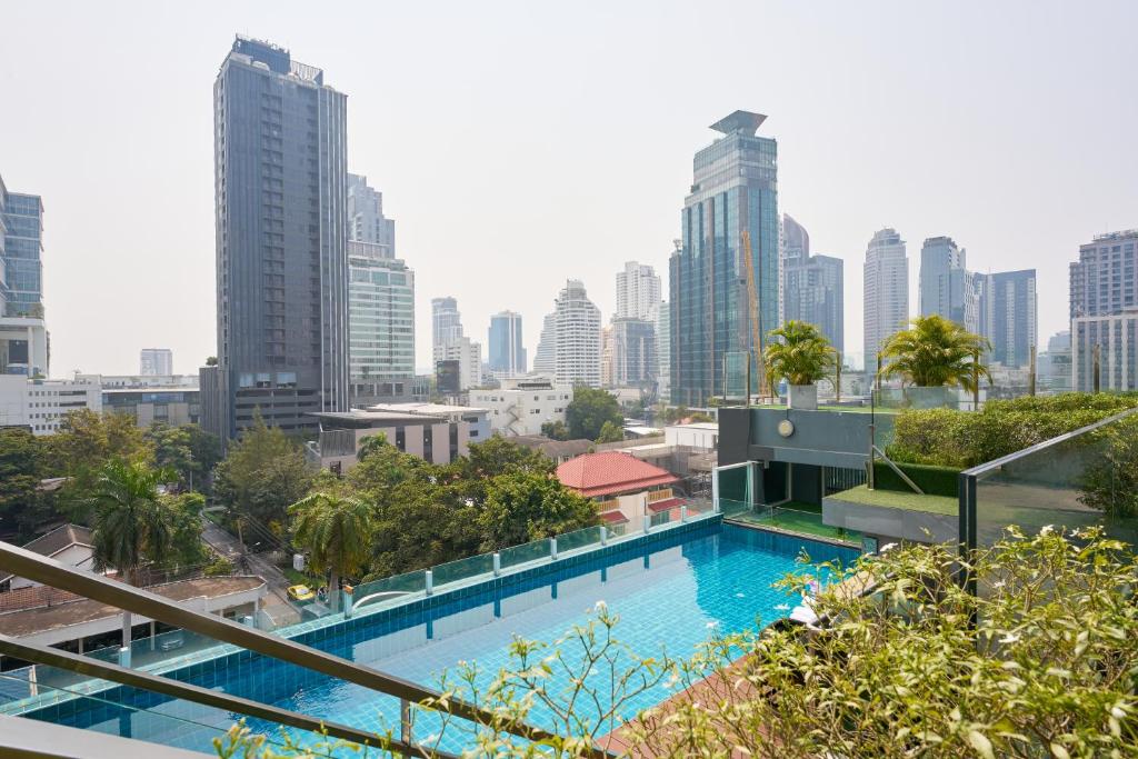 a swimming pool with a city skyline in the background at Shine Aparthotels Sukhumvit Thonglor in Bangkok