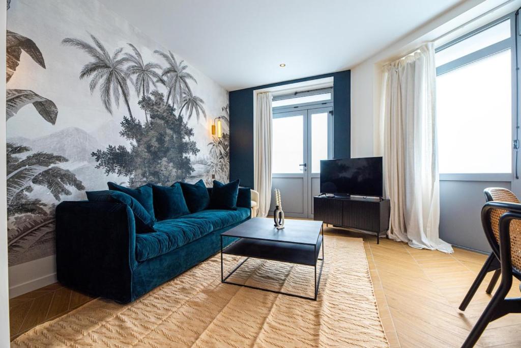 un salon avec un canapé bleu et une télévision dans l'établissement 1 Cozy 1BR Exhibition Centre Porte de Versailles, à Paris