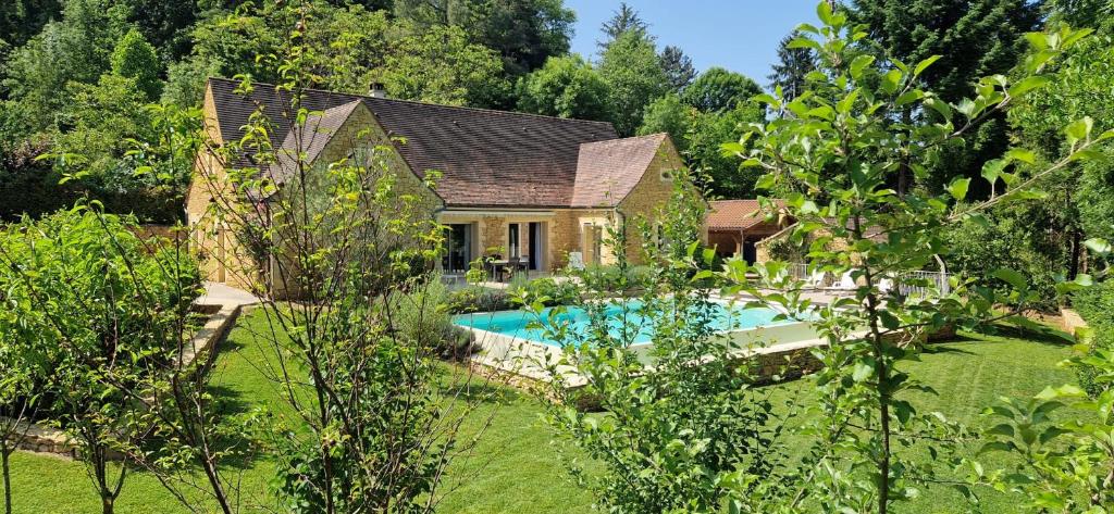 une maison avec une piscine dans une cour dans l'établissement Villa Les jardins de Raiatea, à Sarlat-la-Canéda
