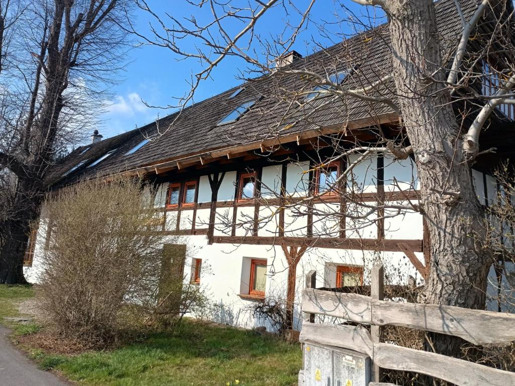 a white house with a fence in front of it at Smocza Chata in Mirsk